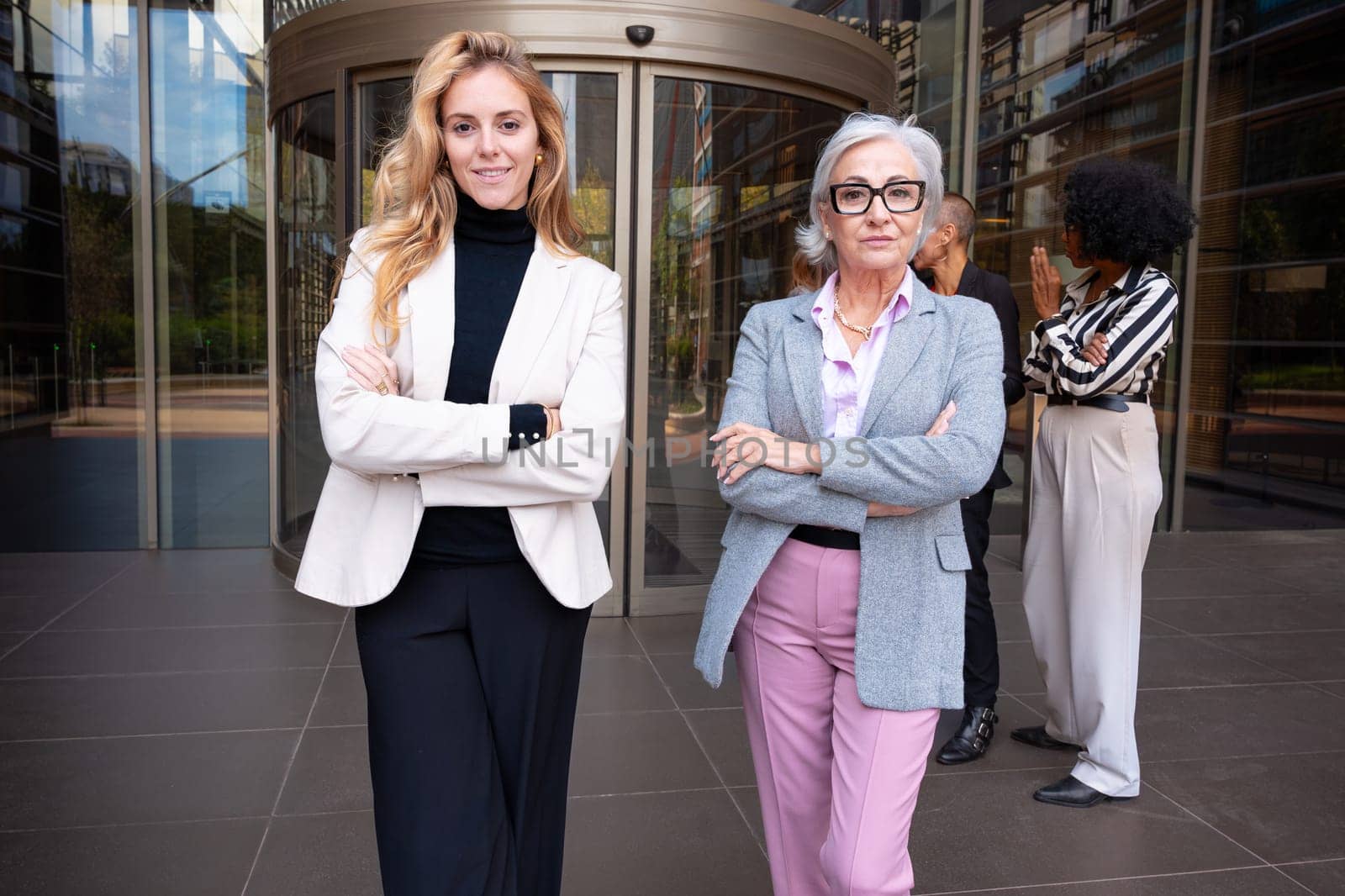 Two smiling Caucasian businesswomen posing for the camera. by mariaphoto3