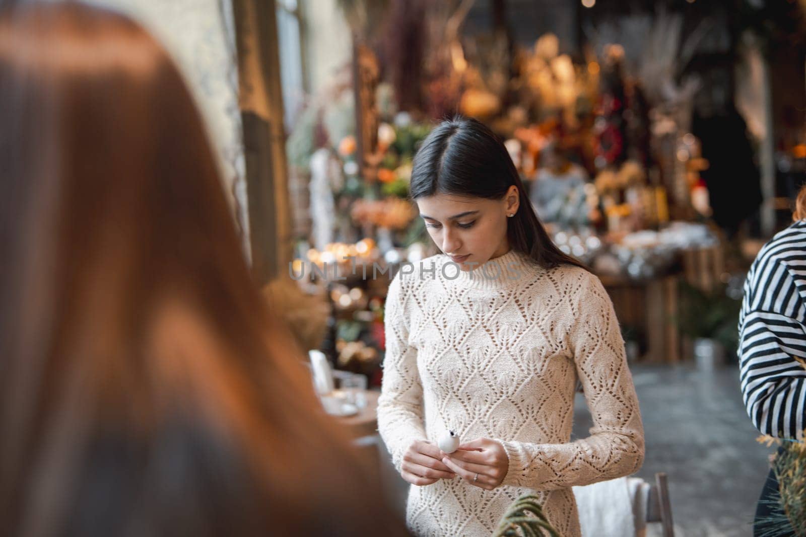 A young lady making a holiday wreath during a crafting class. High quality photo