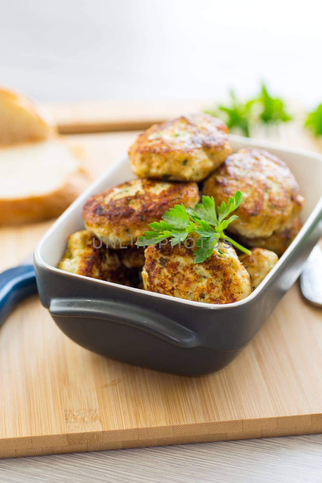 fried meat cutlets in a ceramic form on a wooden table .