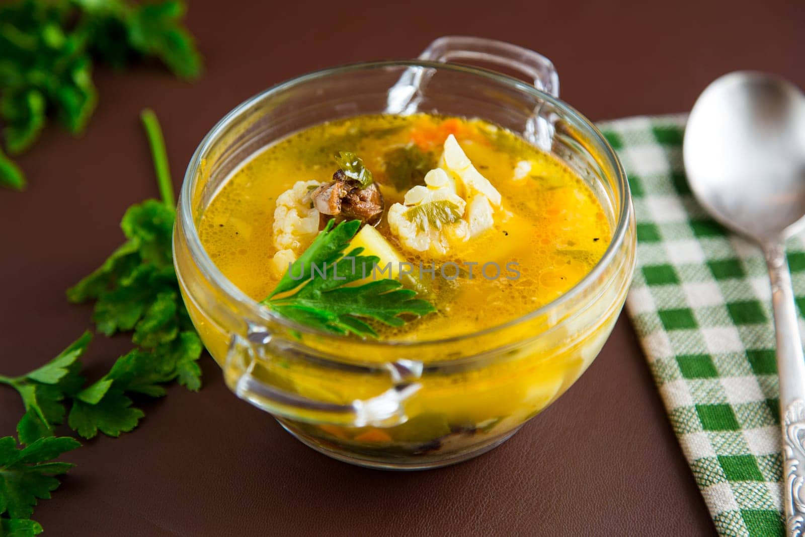 Homemade chicken vegetable soup on rustic wooden background .