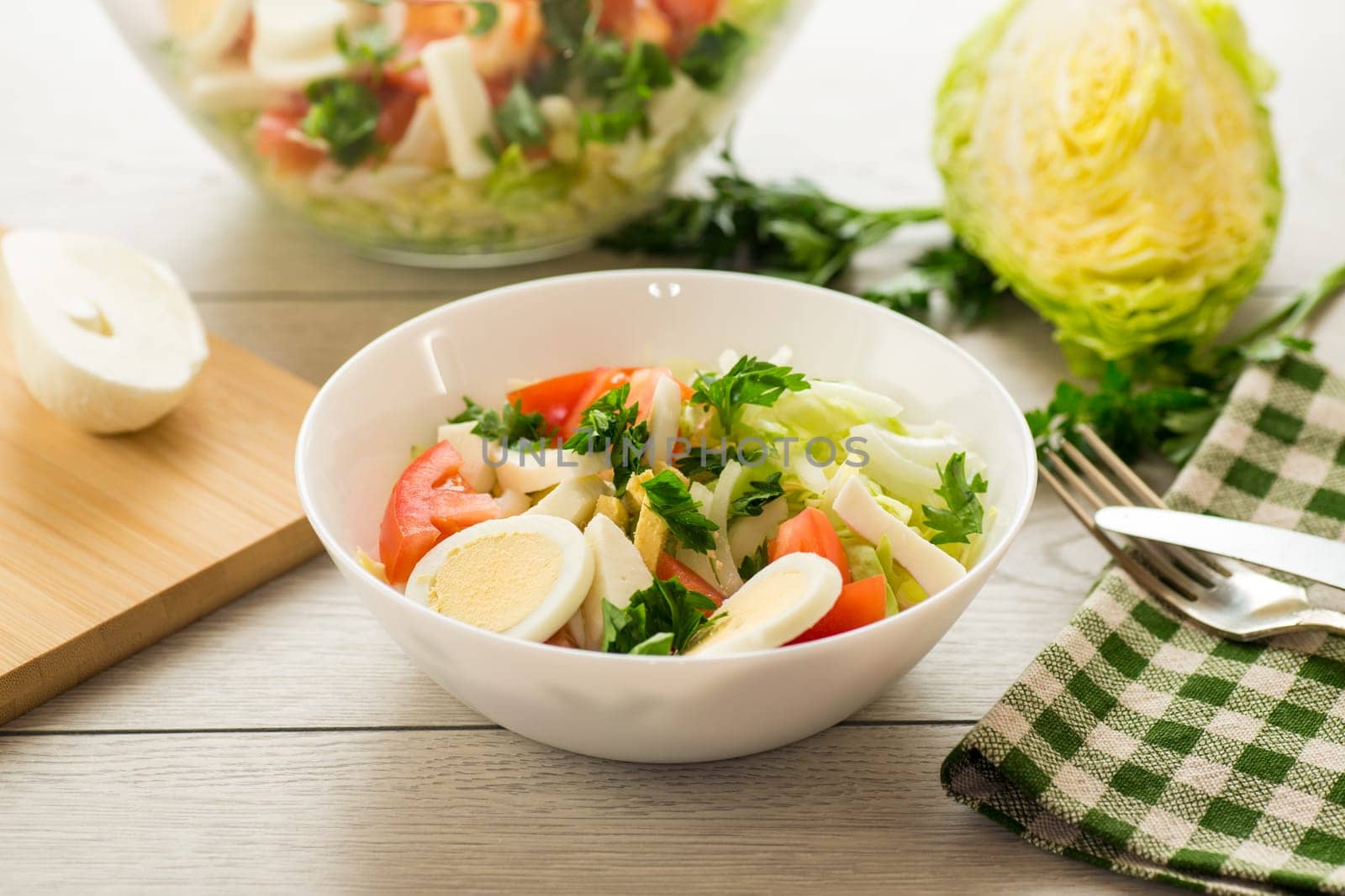 fresh vegetable salad, cabbage, tomatoes in a bowl on a wooden table .