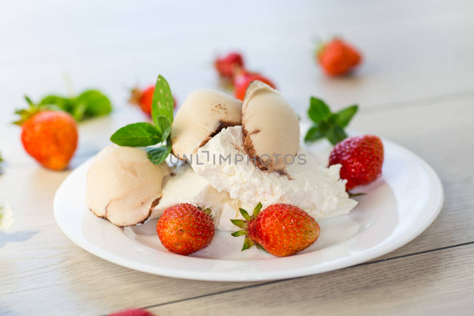 fresh organic cottage cheese with strawberries and ice cream in a plate on a wooden table .