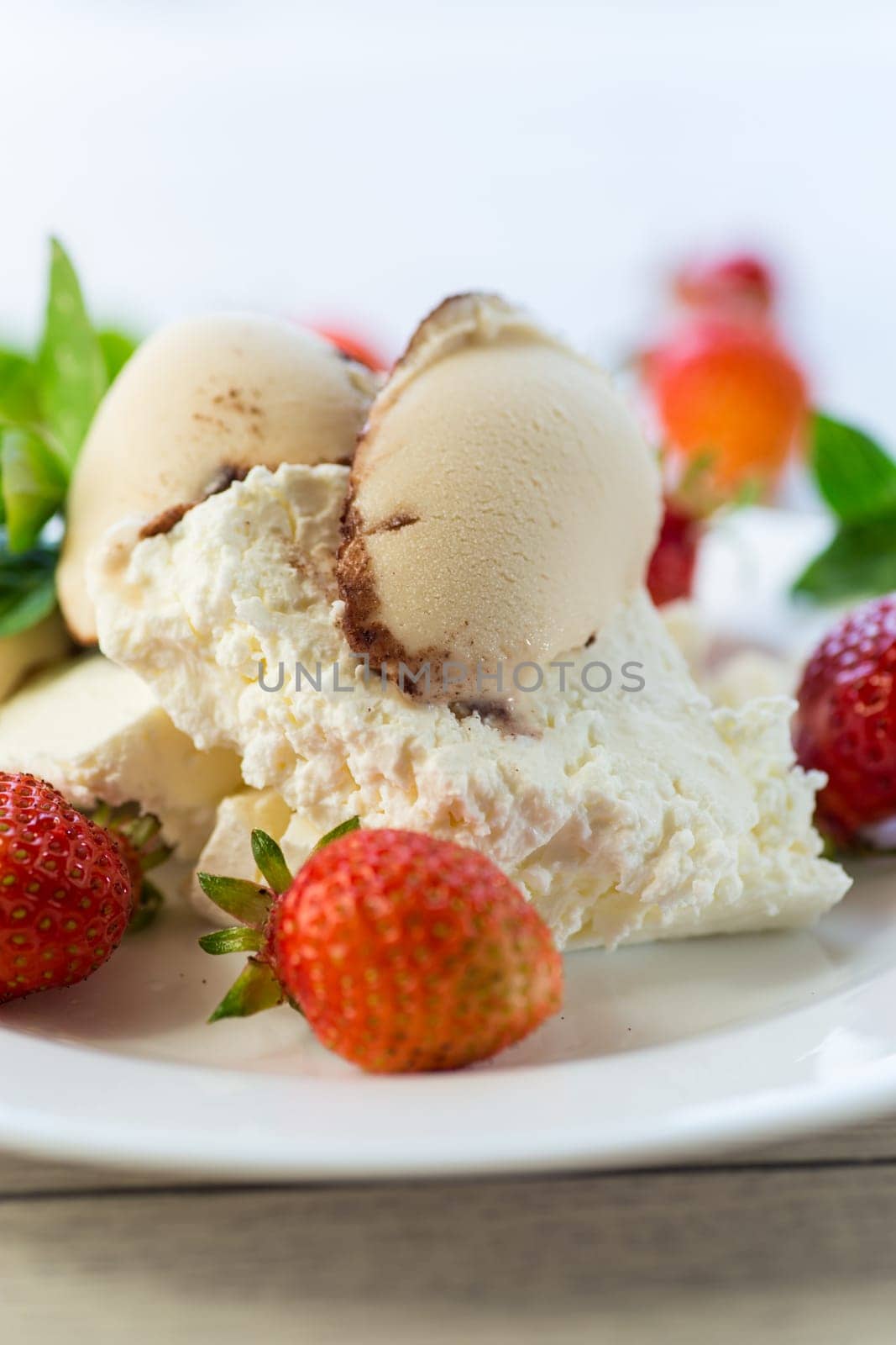 fresh organic cottage cheese with strawberries and ice cream in a plate on a wooden table .