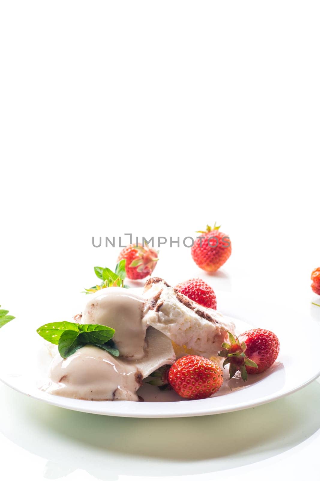 fresh organic cottage cheese with strawberries and ice cream in a plate isolated on white background .