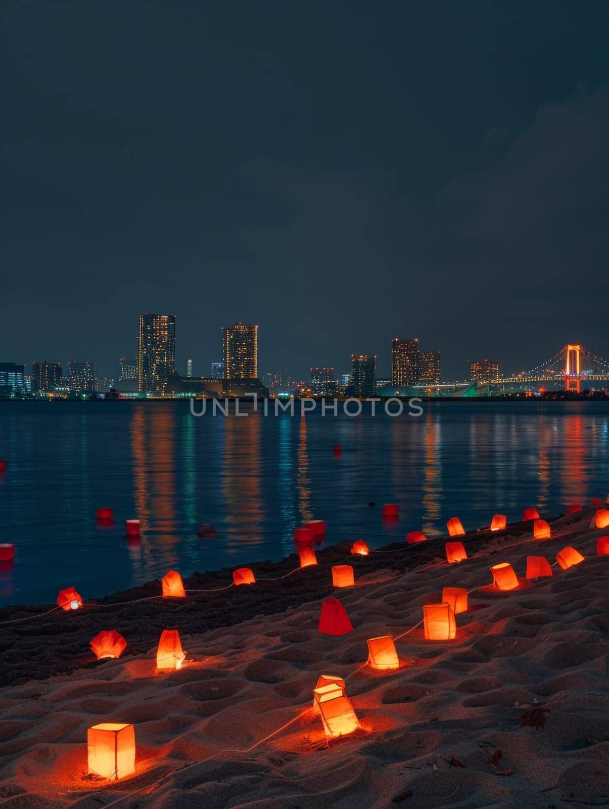 Glowing lanterns on the shore with the stunning Tokyo skyline and illuminated bridge during Marine Day festivities. Japanese Marine Day Umi no Hi also known as Ocean Day or Sea Day.