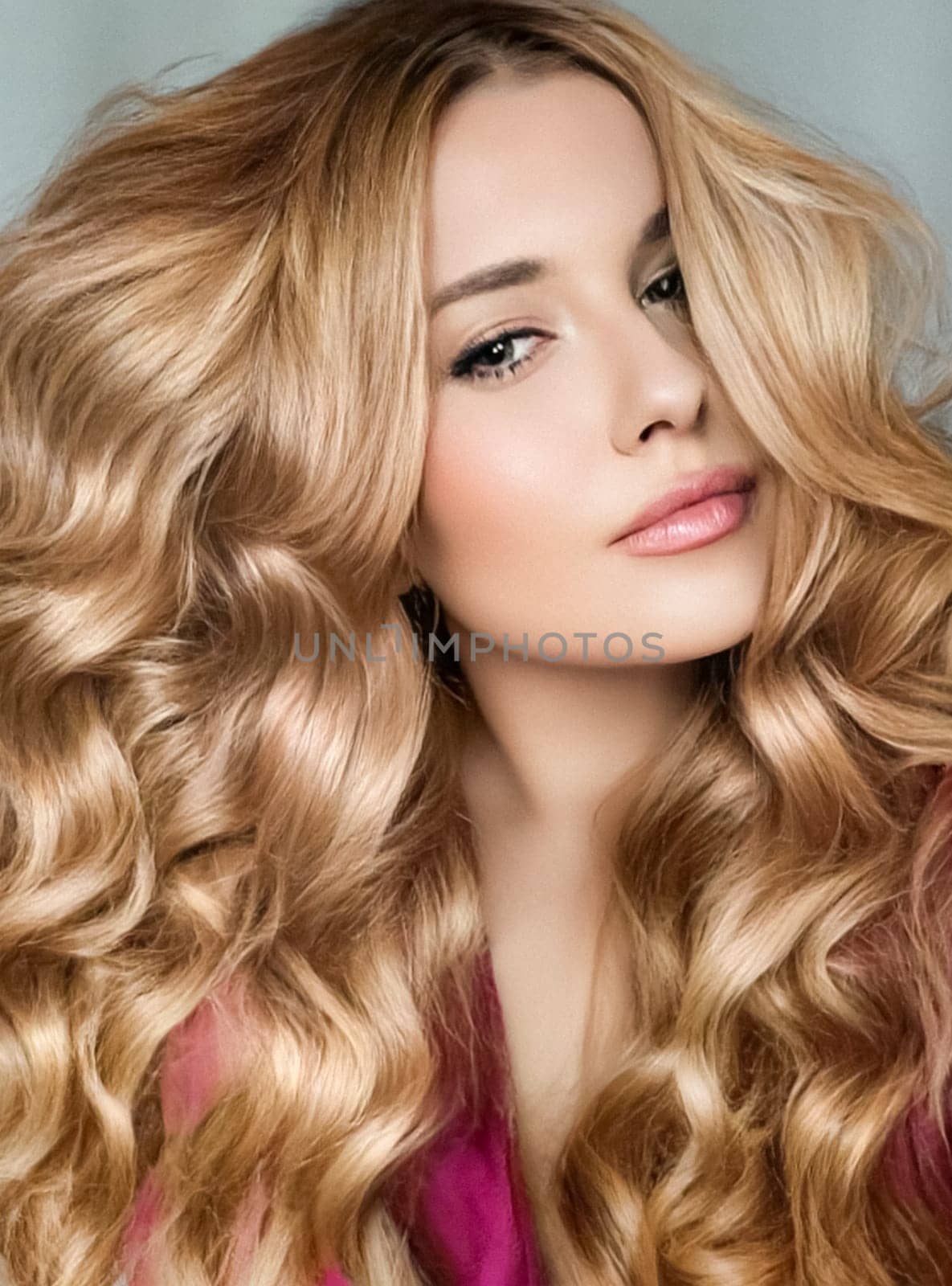 Beautiful blonde woman with curly volume hairstyle, long luxurious hair and beauty makeup, glamorous look face portrait for luxury fashion and natural cosmetics idea