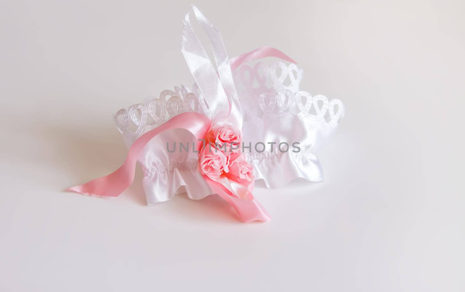 The bride's garter on a pink background. Wedding dress detail.