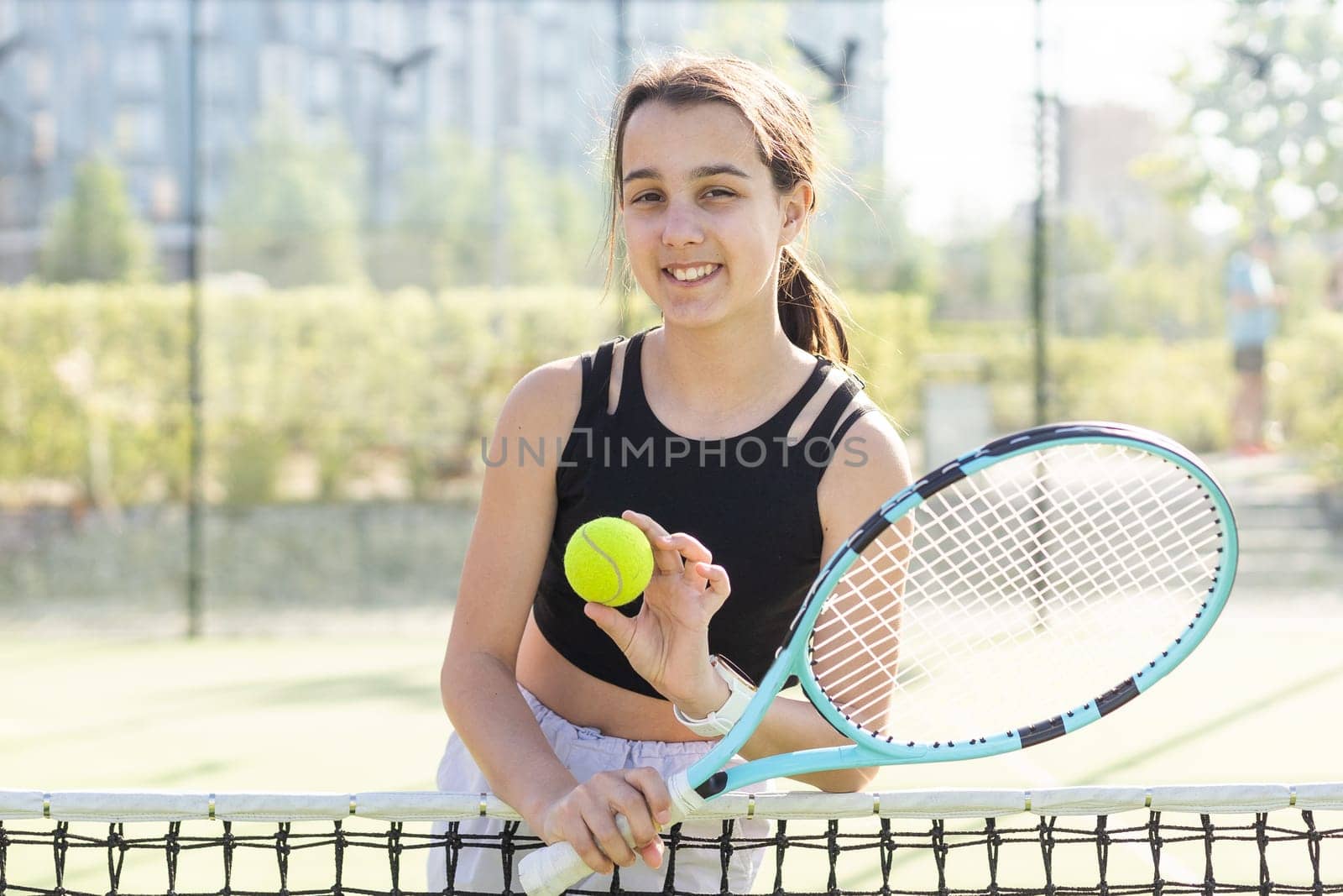 Young woman playing tennis on court by Andelov13