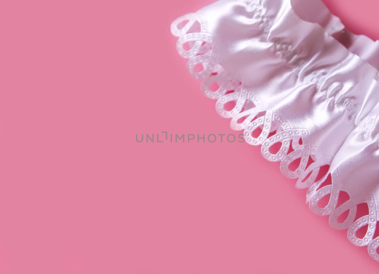 The bride's garter on a pink background. Wedding dress detail.