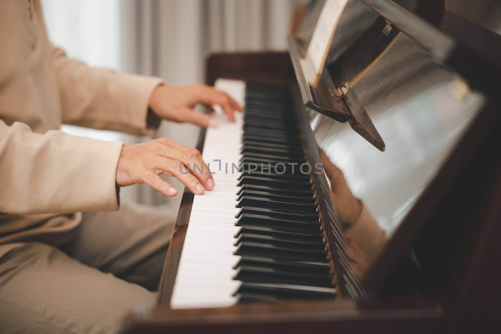 Happy relaxation Asian senior retirement man with eyeglasses learn to play piano at home, elderly old man playing music on piano in living room, lifestyle life after retirement, Close up hands