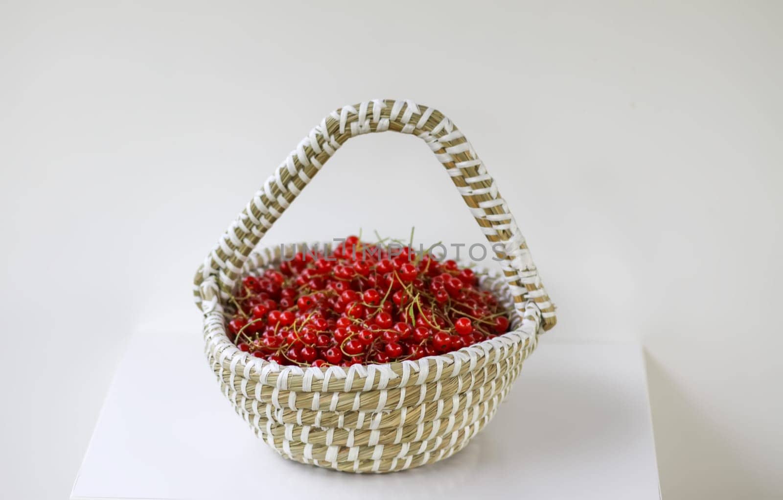 Basket with red currants in the basket. Fresh ripe red berries. Healthy food ingredients.