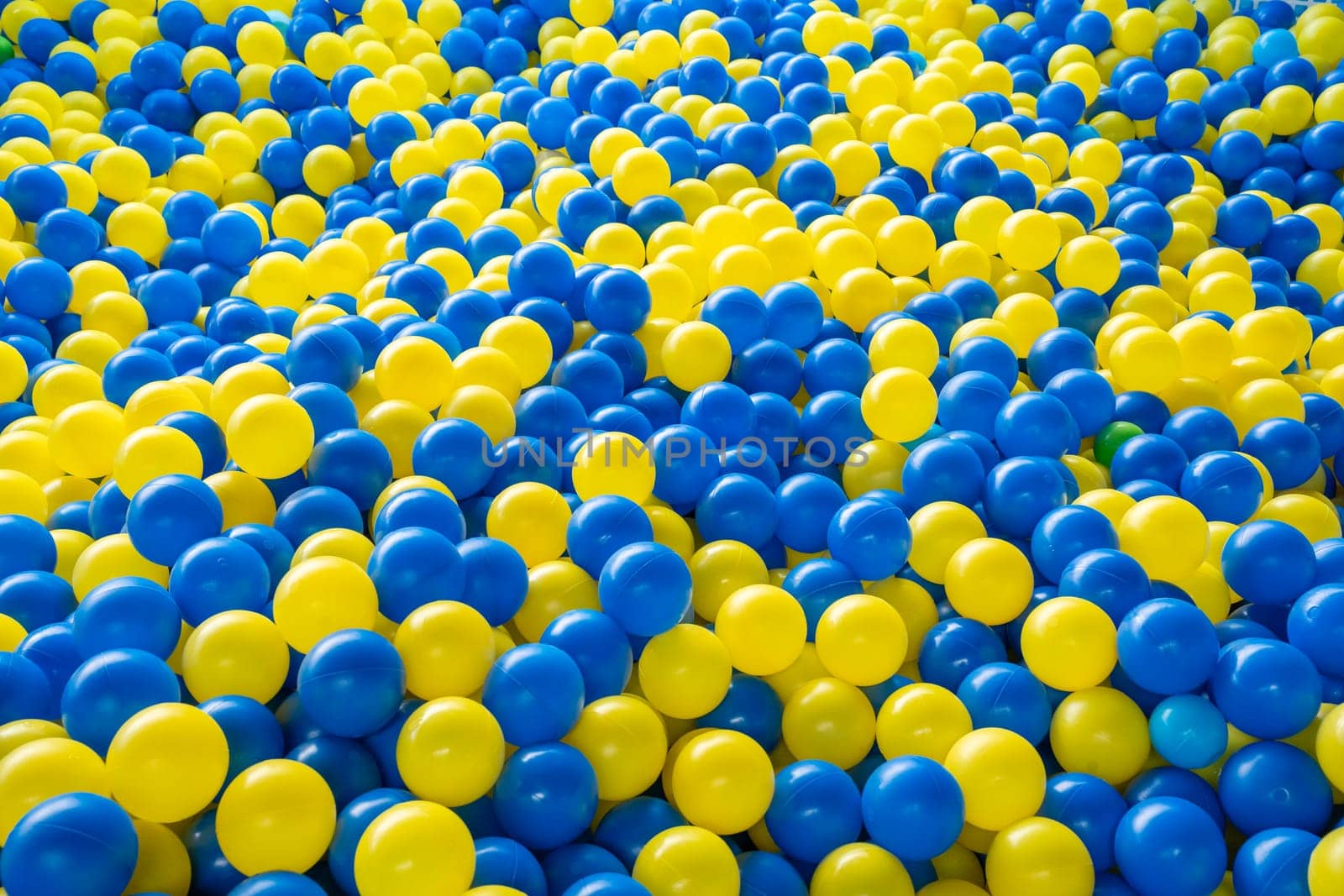 Top view of many colorful balls in ball pool at indoors playground by PaulCarr