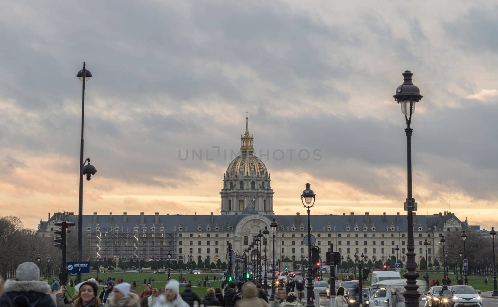 France, Paris - Jan 04, 2024 - The Hotel des Invalides commonly called Les Invalides (Baroque architecture style) containing The Army Museum (Musée de l'Armée) and monuments, all elating to the military history of France, as well as a hospital and an Old Soldiers' retirement home in Paris. Street lighs and traffic on road in the evening, Baroque architecture style, Space for text, Selective focus.