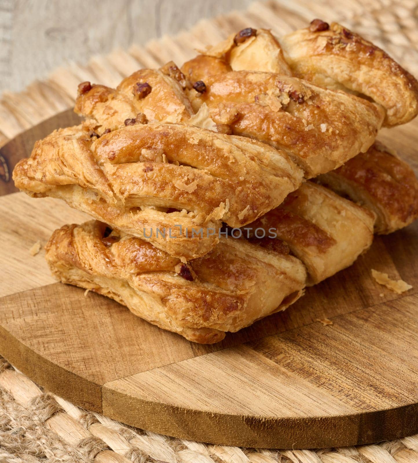 Puff pastry with pecans and maple syrup on a wooden board by ndanko