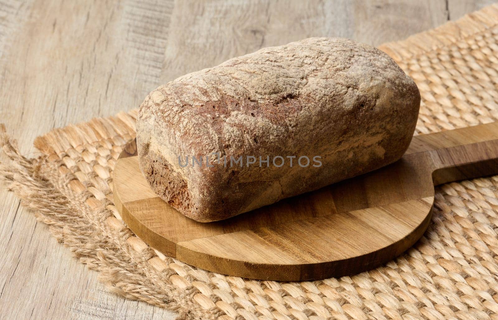 Loaf of rye bread on a wooden board by ndanko