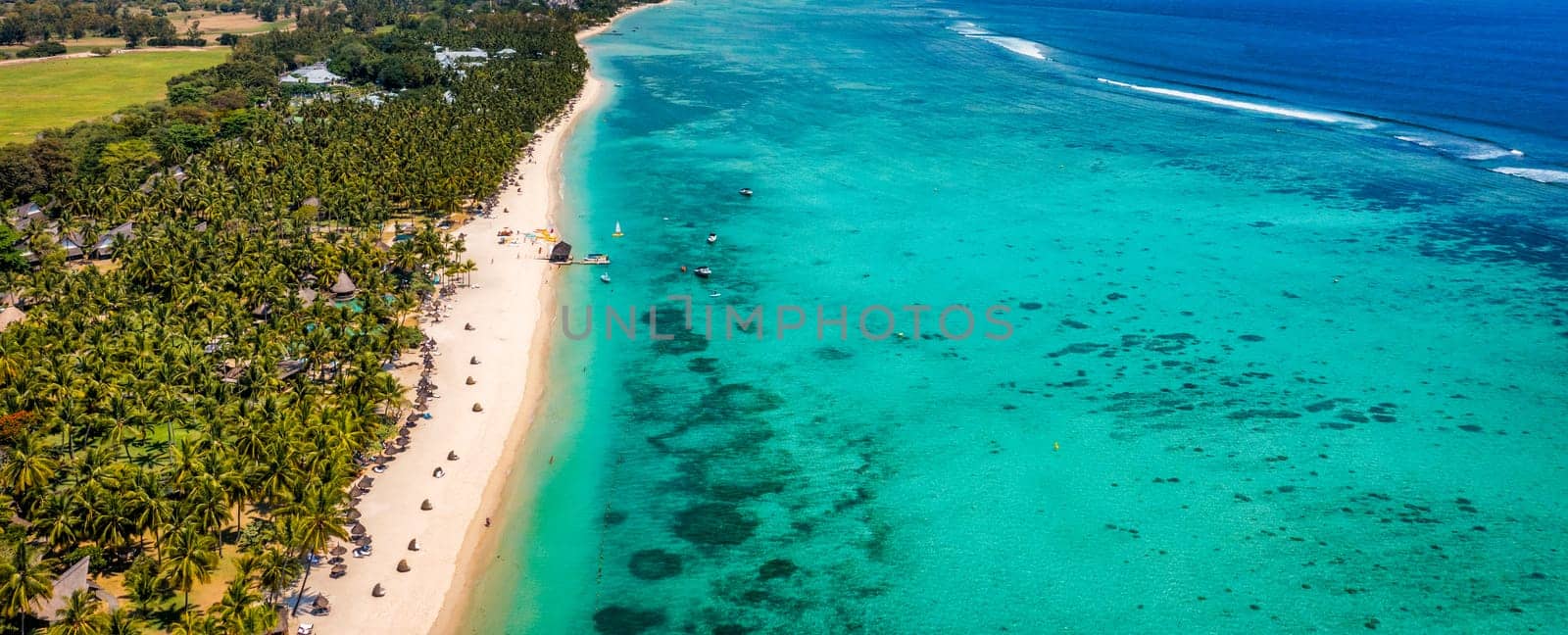 Beautiful Mauritius island with beach Flic en flac. Coral reef around tropical palm beach, Flic en Flac, Mauritius. Aerial view of a beautiful beach along the coast in Flic en Flac, Mauritius.