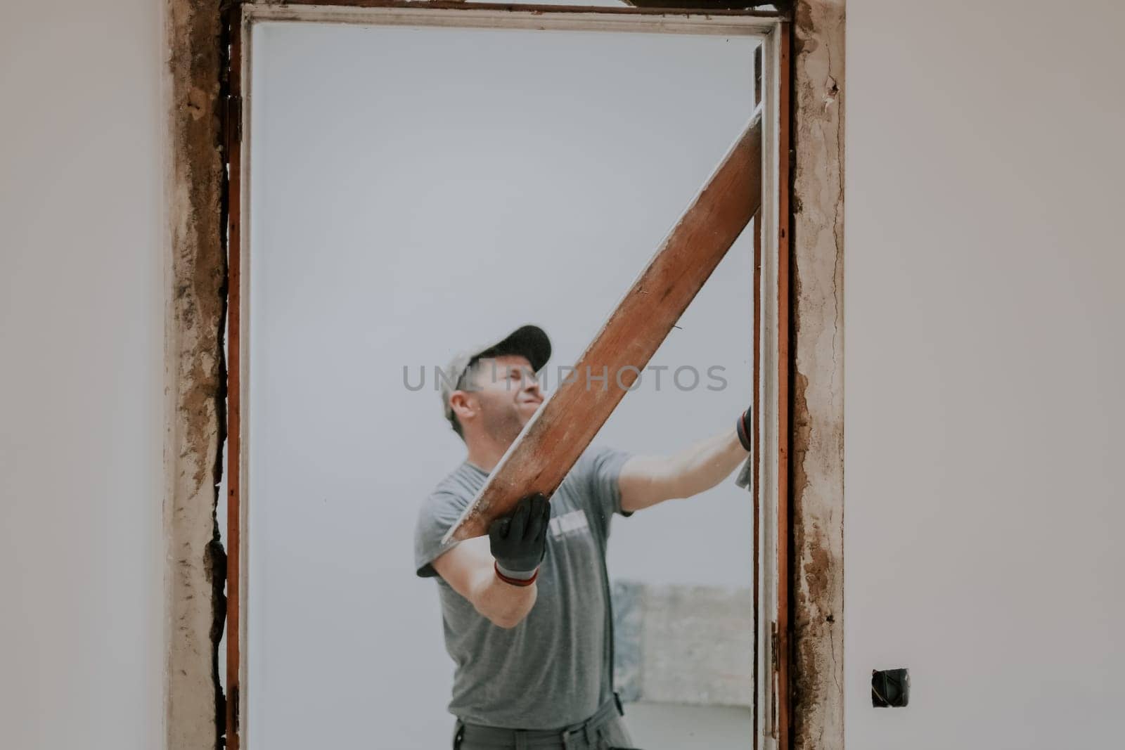 A man working with a crowbar in a doorway. by Nataliya