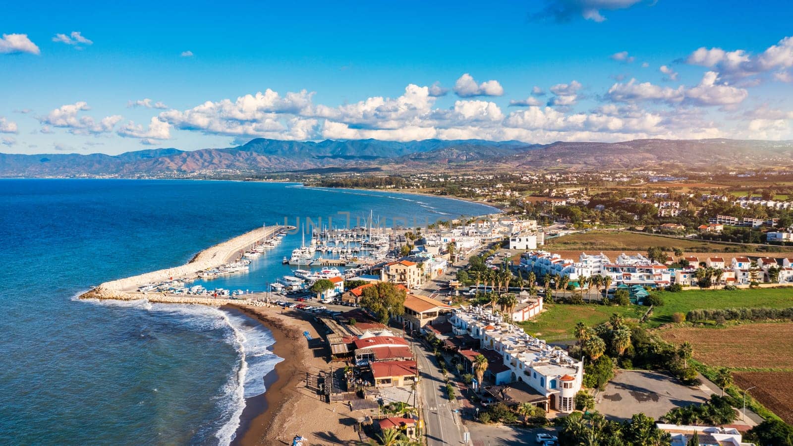 View of Latchi port, Akamas peninsula, Polis Chrysochous, Paphos, Cyprus. The Latsi harbour with boats and yachts, fish restaurant, promenade, beach tourist area and mountains, Latchi, Cyprus.