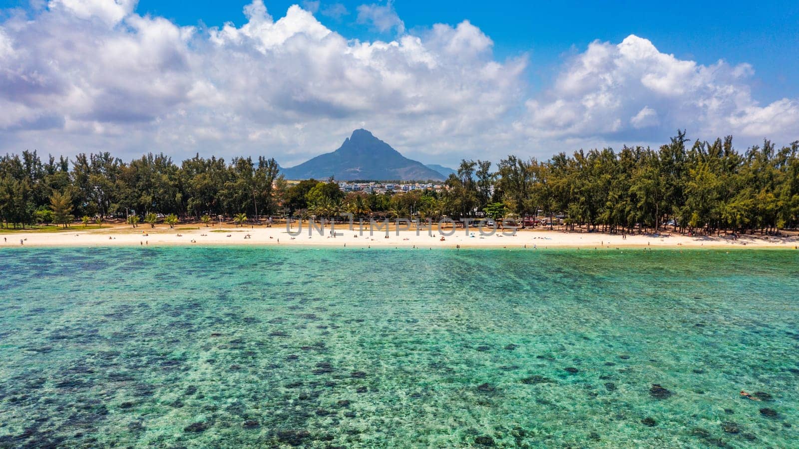 Beach of Flic en Flac with beautiful peaks in the background, Mauritius. Beautiful Mauritius Island with gorgeous beach Flic en Flac, aerial view from drone. Flic en Flac Beach, Mauritius Island.