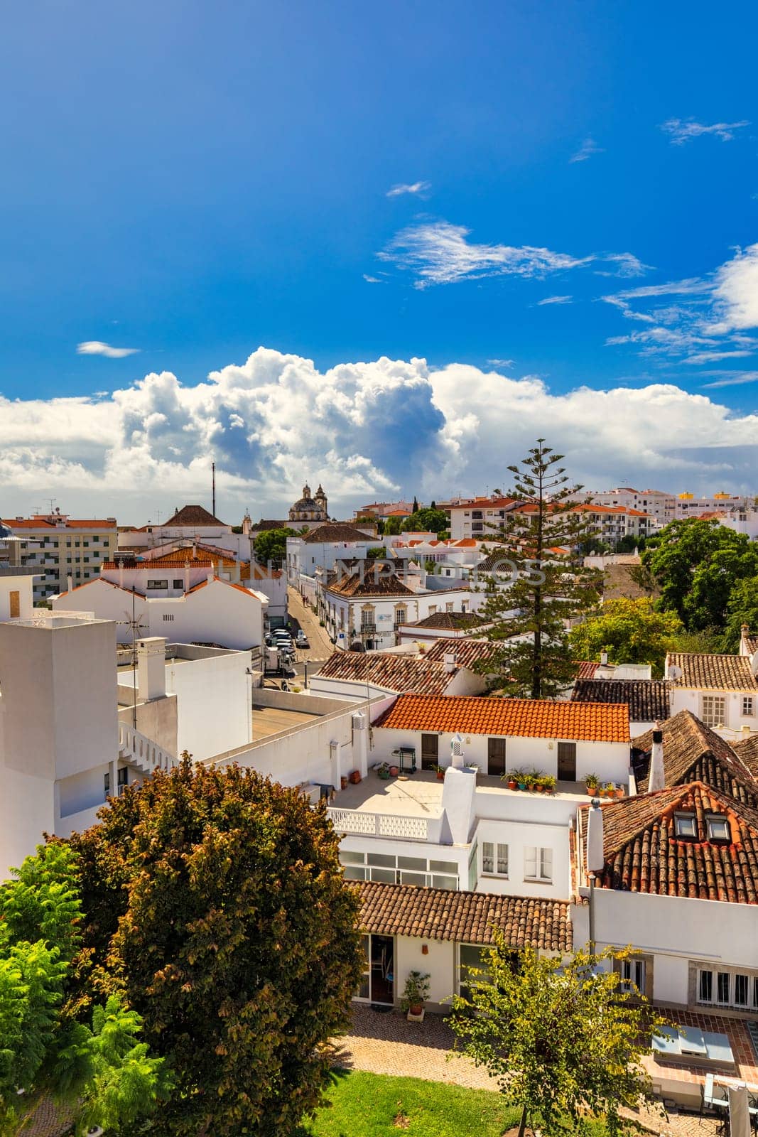 View of the city of Tavira, charming architecture of Tavira, Algarve, Portugal. Santiago of Tavira church in the old town of the beautiful city of Tavira in a sunny day. Algarve region, Portugal by DaLiu