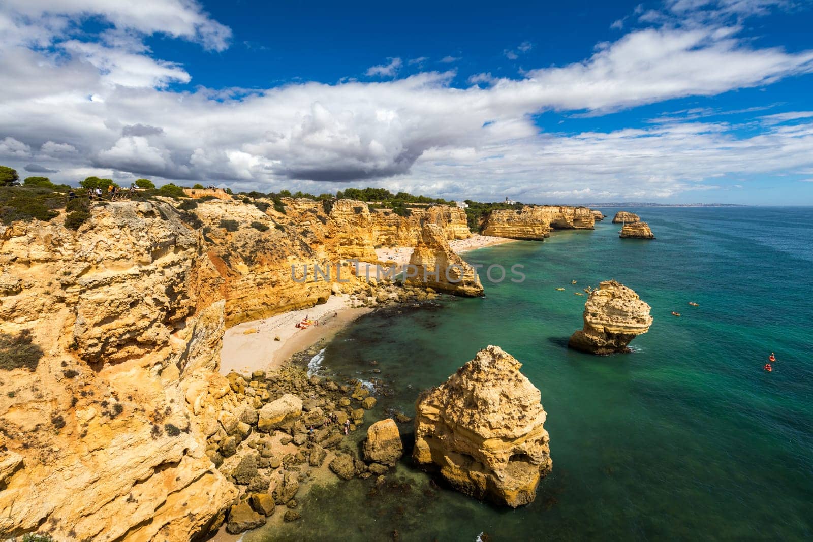 Praia da Marinha, beautiful beach Marinha in Algarve, Portugal. Navy Beach (Praia da Marinha) with flying seagulls over the beach, located on the Atlantic coast in Lagoa Municipality, Algarve. by DaLiu