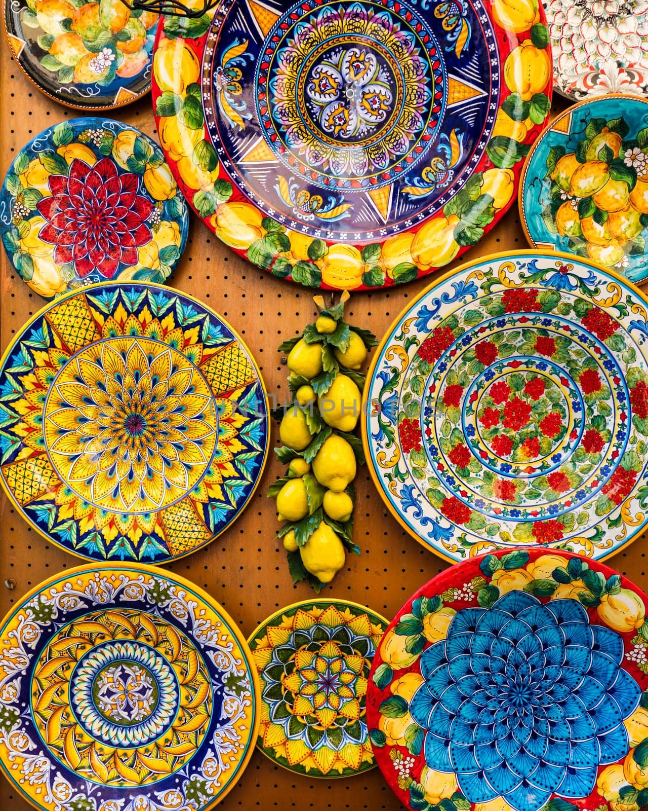 Collection of colorful Italian ceramic pottery, local craft products from Positano, Italy. Ceramic plates display in Positano, Italy. Colorful of vintage ceramic plates in Positano, Italy.