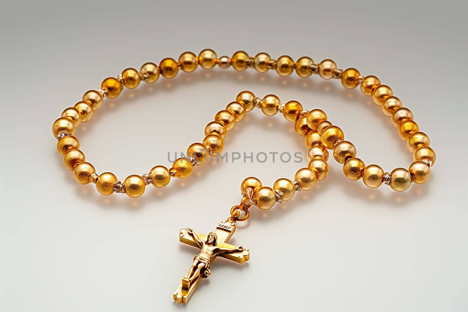 A gold rosary adorned with a cross hanging as a symbolic religious artifact.