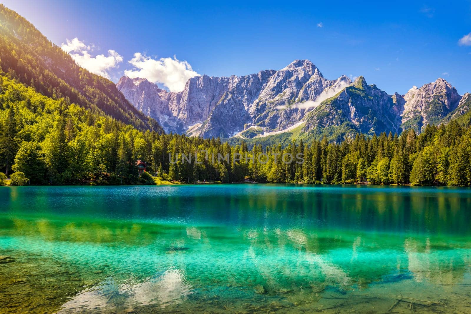 Picturesque lake Lago Fusine in Italy. Fusine lake with Mangart peak on background. Popular travel destination of Julian Alps. Location: Tarvisio comune , Province of Udine, Italy, Europe.