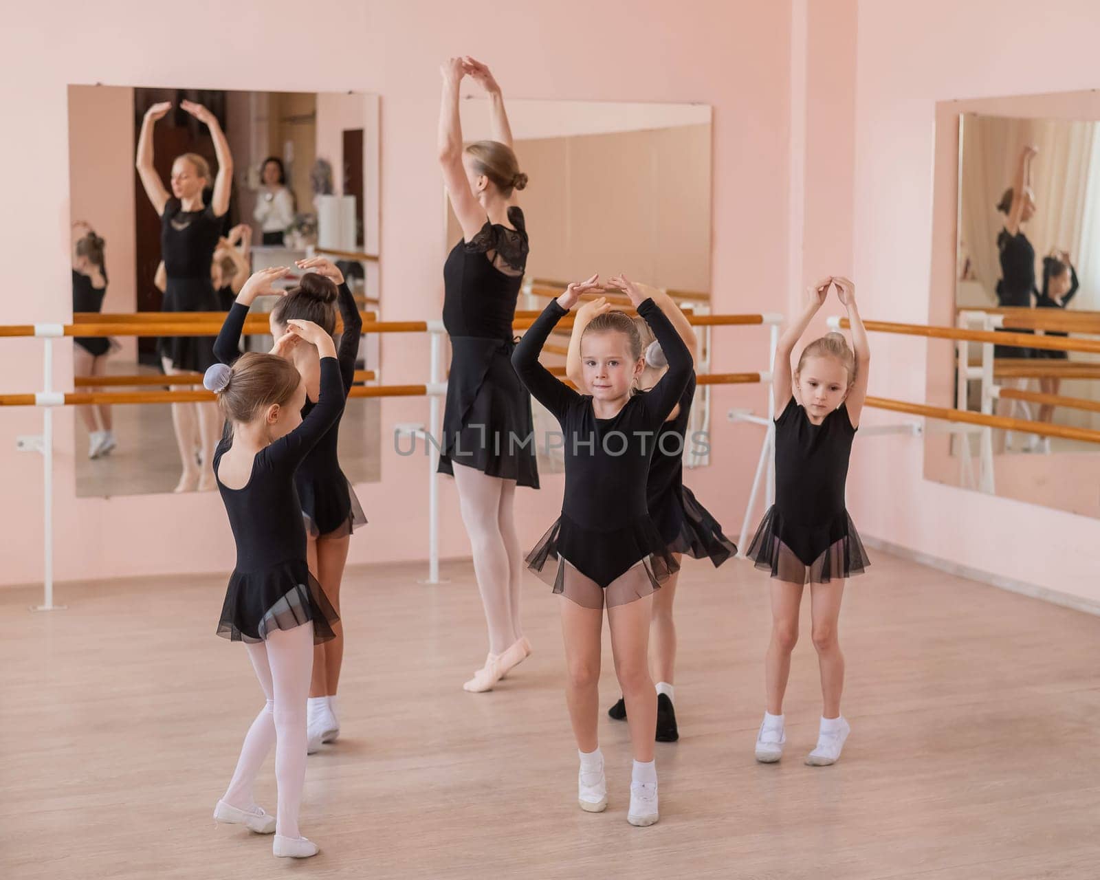 Children's ballet school. Caucasian woman teaching ballet to little girls. by mrwed54