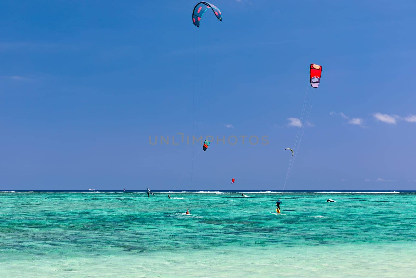 Kite surfers in the waters of Indian Ocean, Mauritius. Kite surfing in the clear waters of the Indian Ocean in Le Morne beach, Mauritius. Best Kite surfing experience at Mauritius island.