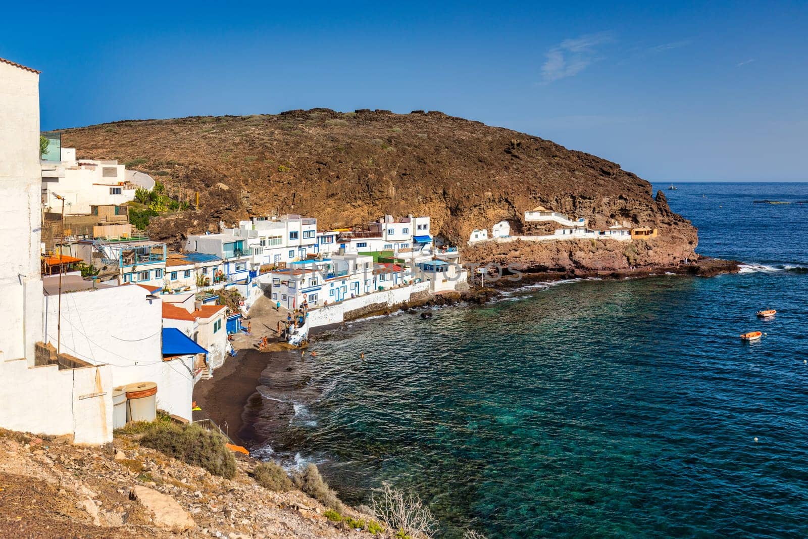 Landscape with Playa de Tufia on Gran Canaria, Spain. Cove Playa de Tufia and small Tufia village, including some cave houses. Small village Tufia with Playa de Tufia on Gran Canaria, Spain, Europe.