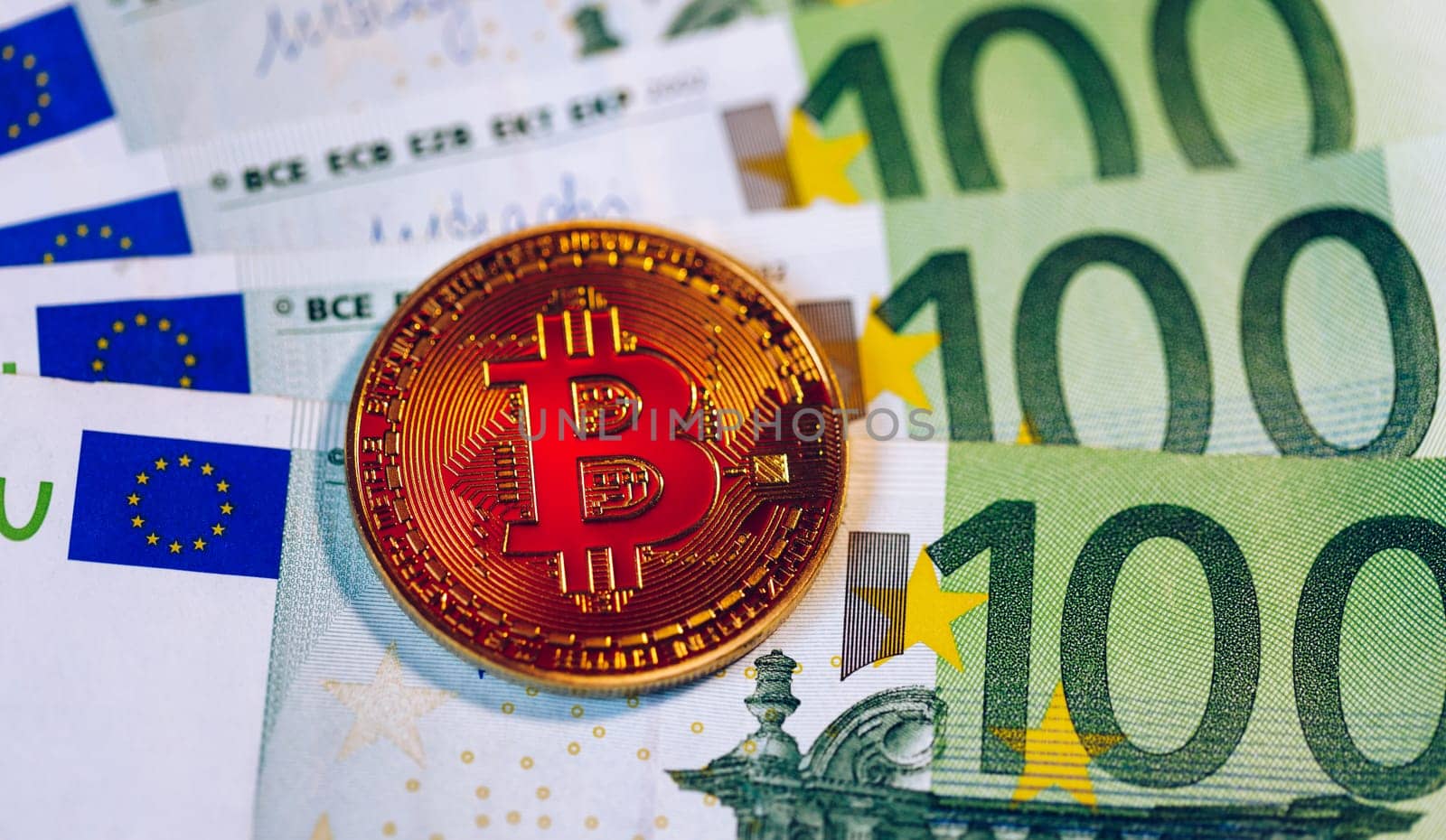 Golden bitcoin over Euro money. Bitcoin cryptocurrency. Crypto currency concept. Bitcoin with euro bills. Bitcoins stacked on euro banknotes.