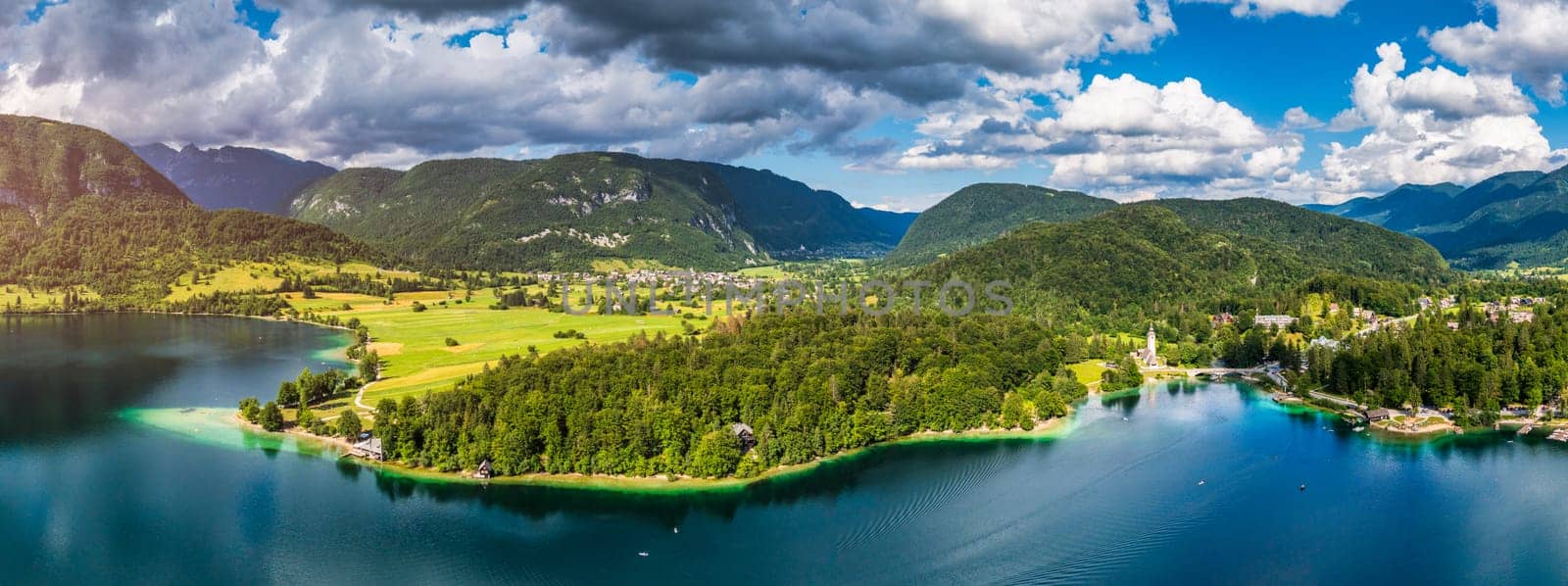 Aerial view of Bohinj lake in Julian Alps. Popular touristic destination in Slovenia. Bohinj Lake, Church of St John the Baptist. Triglav National Park, Julian Alps, Slovenia. 