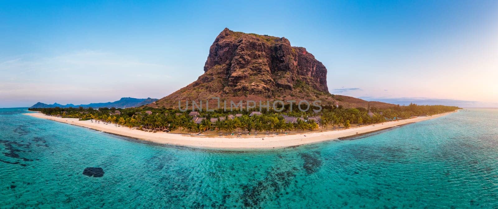 Paradise beach resort with palm trees and and tropical sea in Mauritius island. Summer vacation and tropical beach concept. Sandy beach with Le Morne beach on Mauritius island. Tropical landscape.