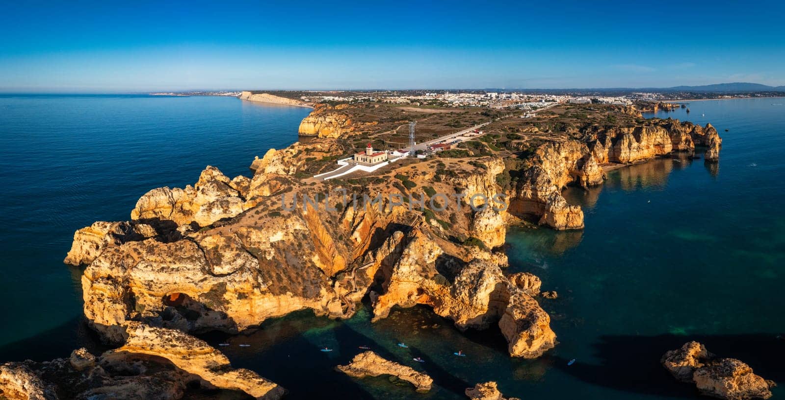 Panoramic view, Ponta da Piedade near Lagos in Algarve, Portugal. Cliff rocks and tourist boat on sea at Ponta da Piedade, Algarve region, Portugal. Ponta da Piedade, Algarve region, Portugal.