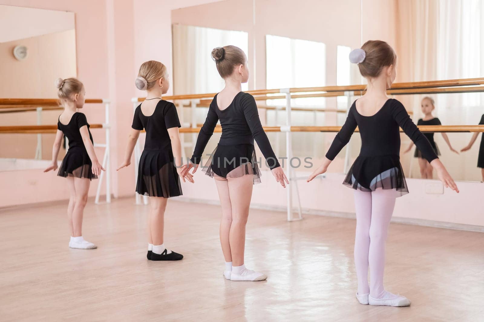 Cute little girls in black swimsuits and tutu practice ballet in class. by mrwed54