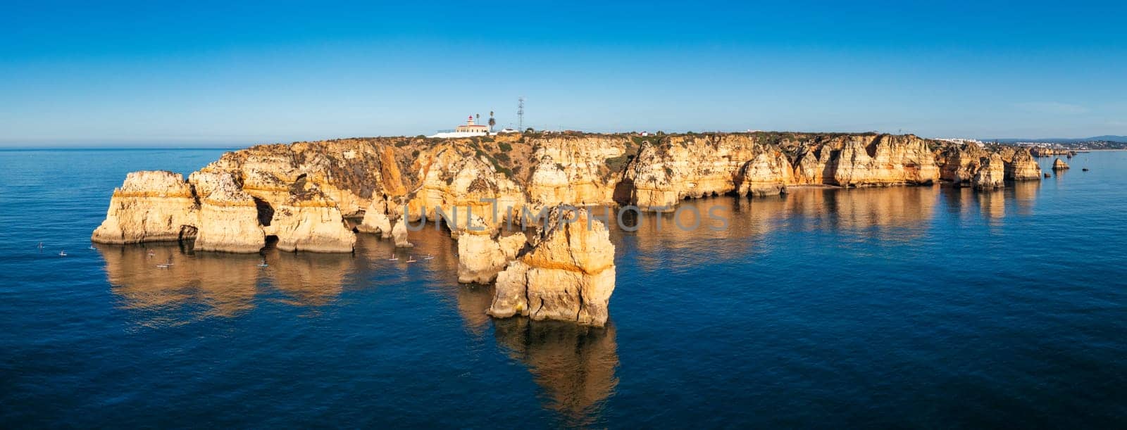 Panoramic view, Ponta da Piedade near Lagos in Algarve, Portugal. Cliff rocks and tourist boat on sea at Ponta da Piedade, Algarve region, Portugal. Ponta da Piedade, Algarve region, Portugal.