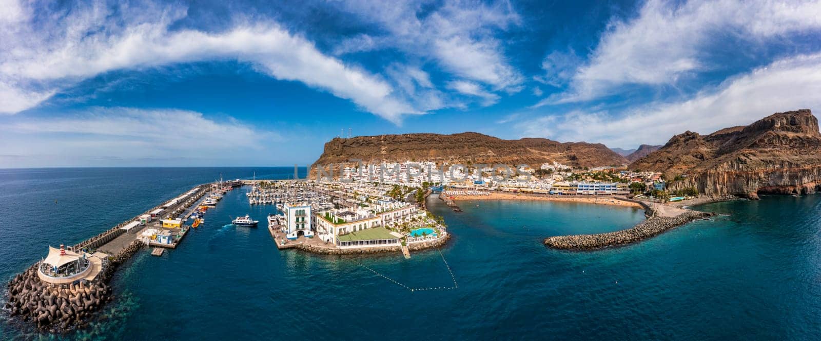 Puerto de Mogan with the beach in Gran Canaria, Spain. Favorite vacation place for tourists and locals on island. Harbor in Puerto de Mogan and Playa Mogan on Grand Canary Island, Spain.