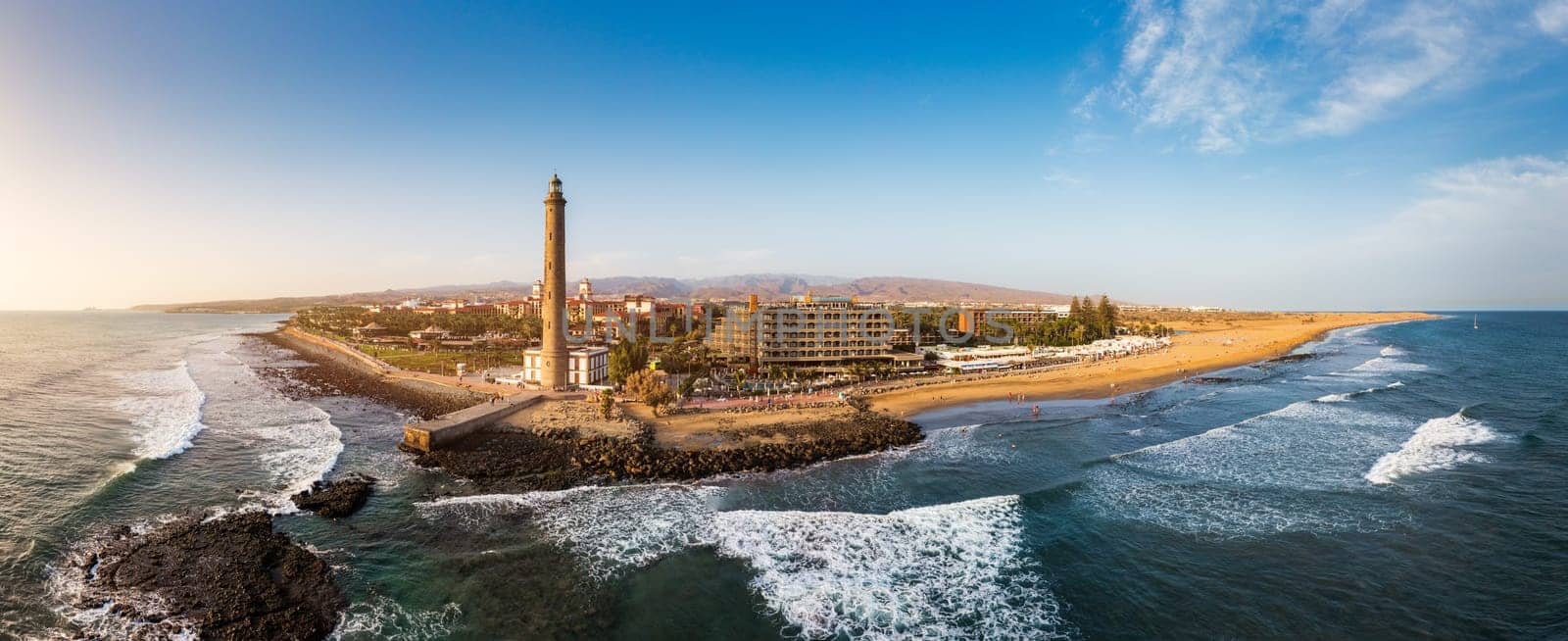 Lighthouse of Maspalomas at Gran Canaria Island known as Faro de Maspalomas at sunset. Seascape with lighthouse and Maspalomas beach. Gran Canaria, Canary Islands, Spain