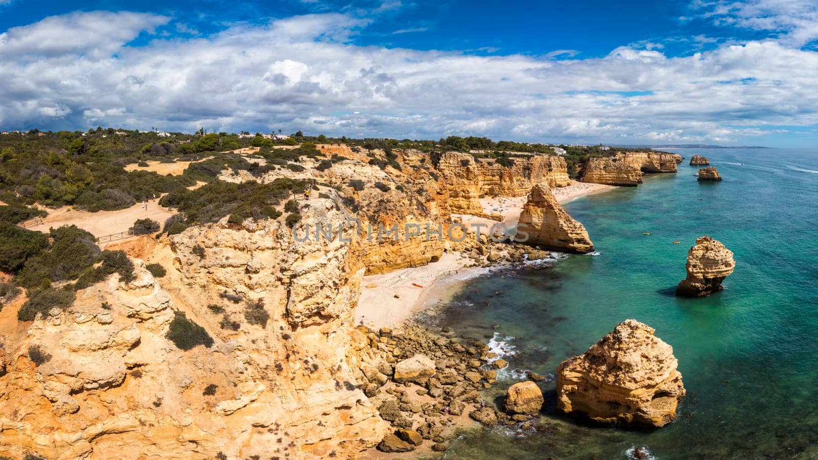 Praia da Marinha, beautiful beach Marinha in Algarve, Portugal. Navy Beach (Praia da Marinha) with flying seagulls over the beach, located on the Atlantic coast in Lagoa Municipality, Algarve.