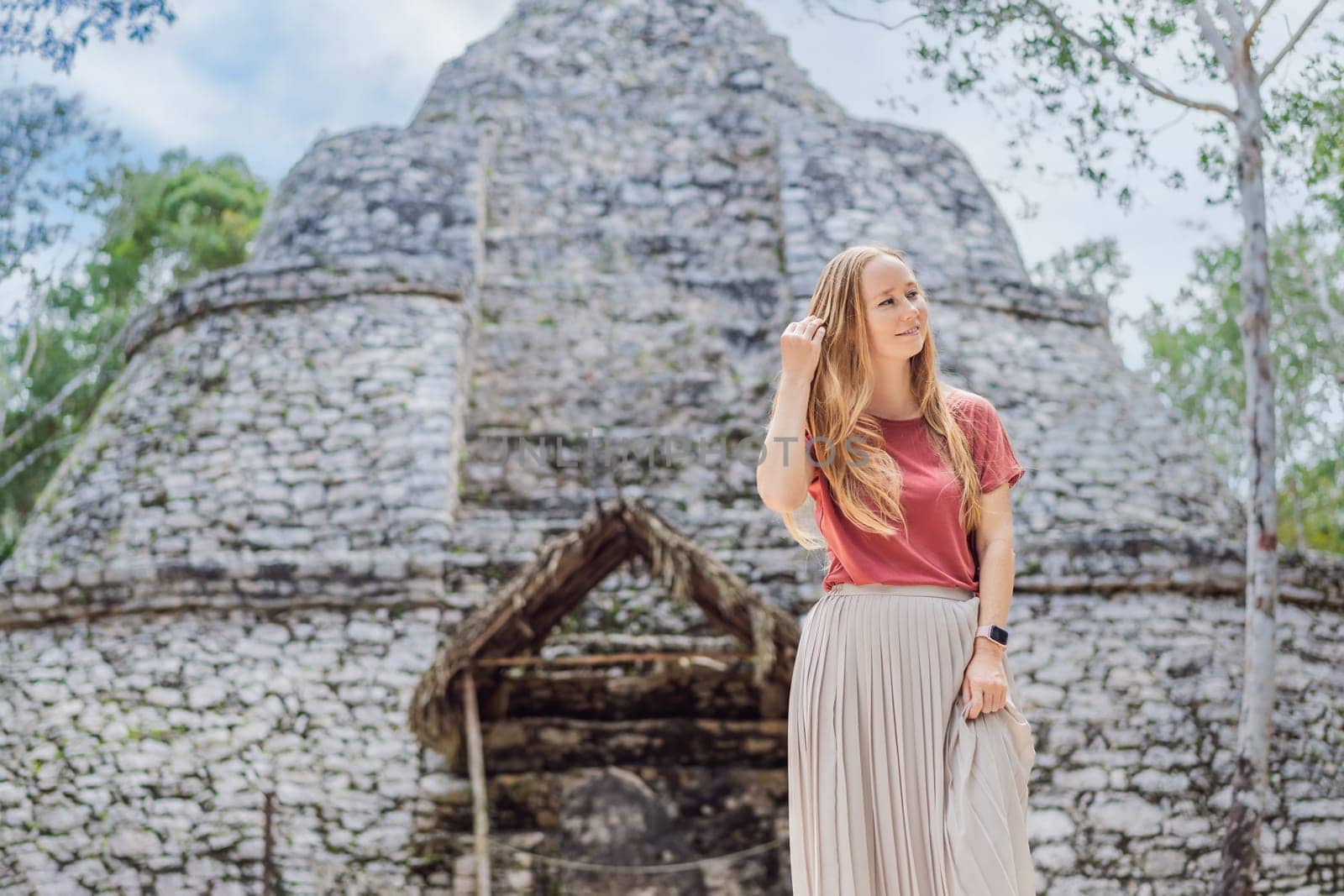 Woman tourist at Coba, Mexico. Ancient mayan city in Mexico. Coba is an archaeological area and a famous landmark of Yucatan Peninsula. Cloudy sky over a pyramid in Mexico.