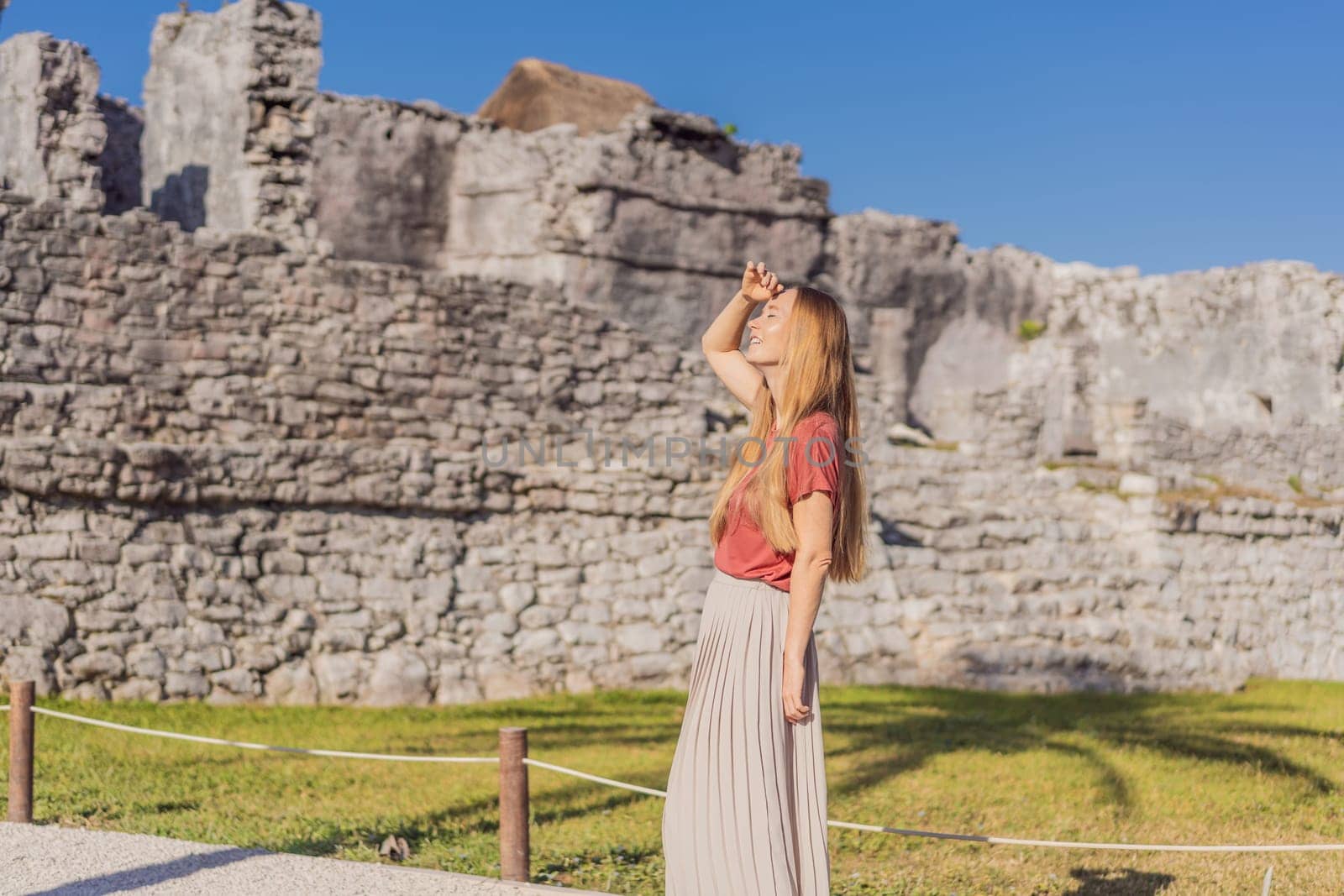 Woman tourist enjoying the view Pre-Columbian Mayan walled city of Tulum, Quintana Roo, Mexico, North America, Tulum, Mexico. El Castillo - castle the Mayan city of Tulum main temple.