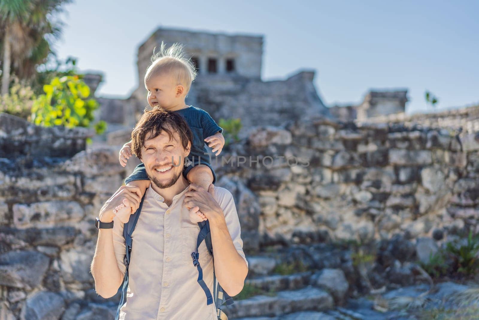 Father and son tourists enjoying the view Pre-Columbian Mayan walled city of Tulum, Quintana Roo, Mexico, North America, Tulum, Mexico. El Castillo - castle the Mayan city of Tulum main temple.