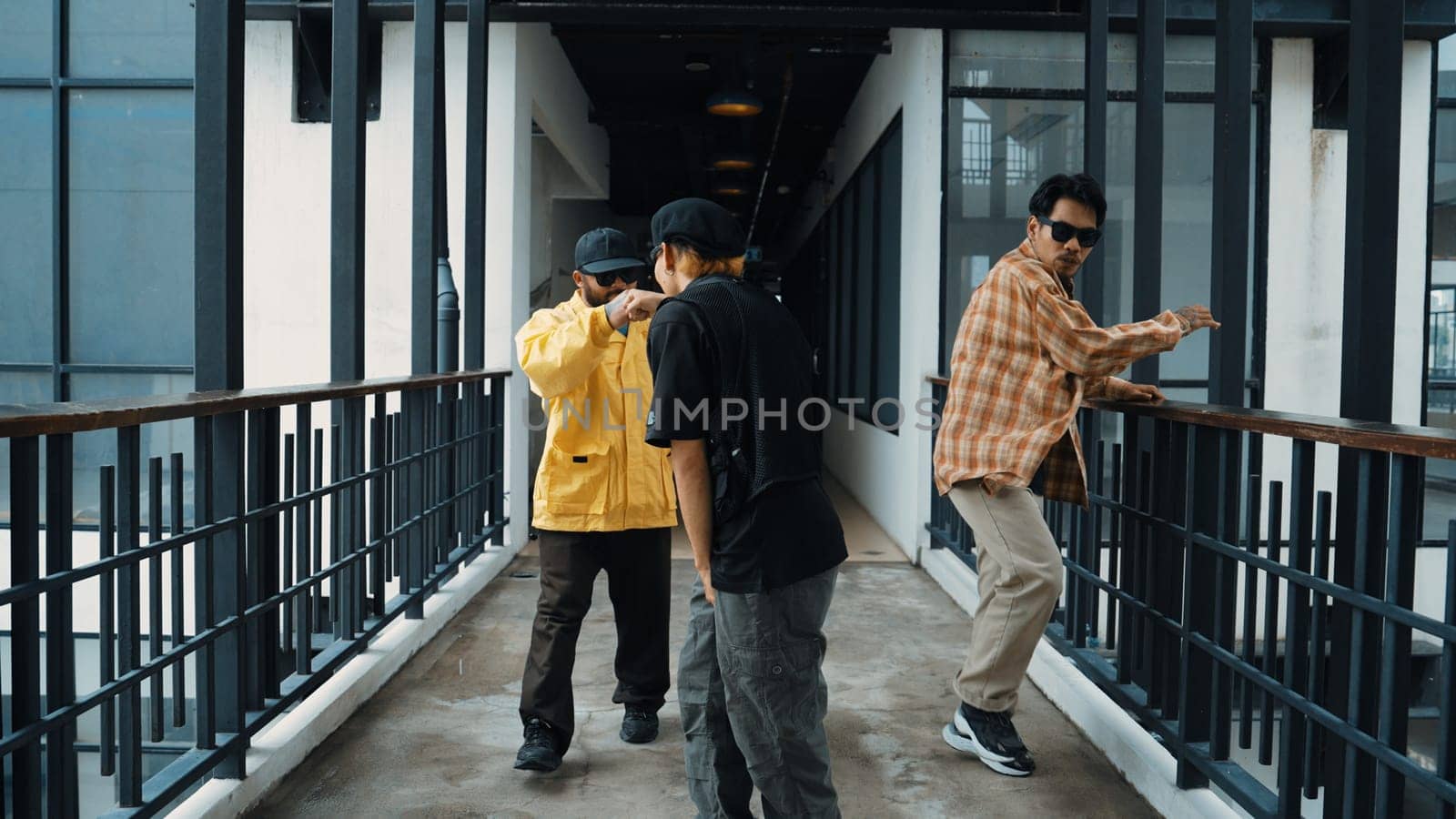 Group of smart hipster walking at modern bridge while pose at camera. Attractive handsome street dancer group looking at camera while dancing. Active, cool. Outdoor sport 2024. Endeavor.