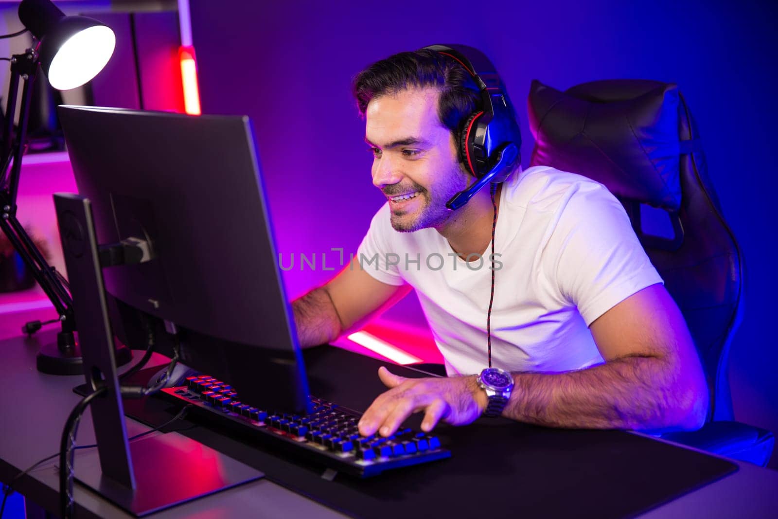 Smart gaming streamer talking with team member players using headset and mic for communicate with others on streaming live on social media application at digital neon lighting studio room. Surmise.