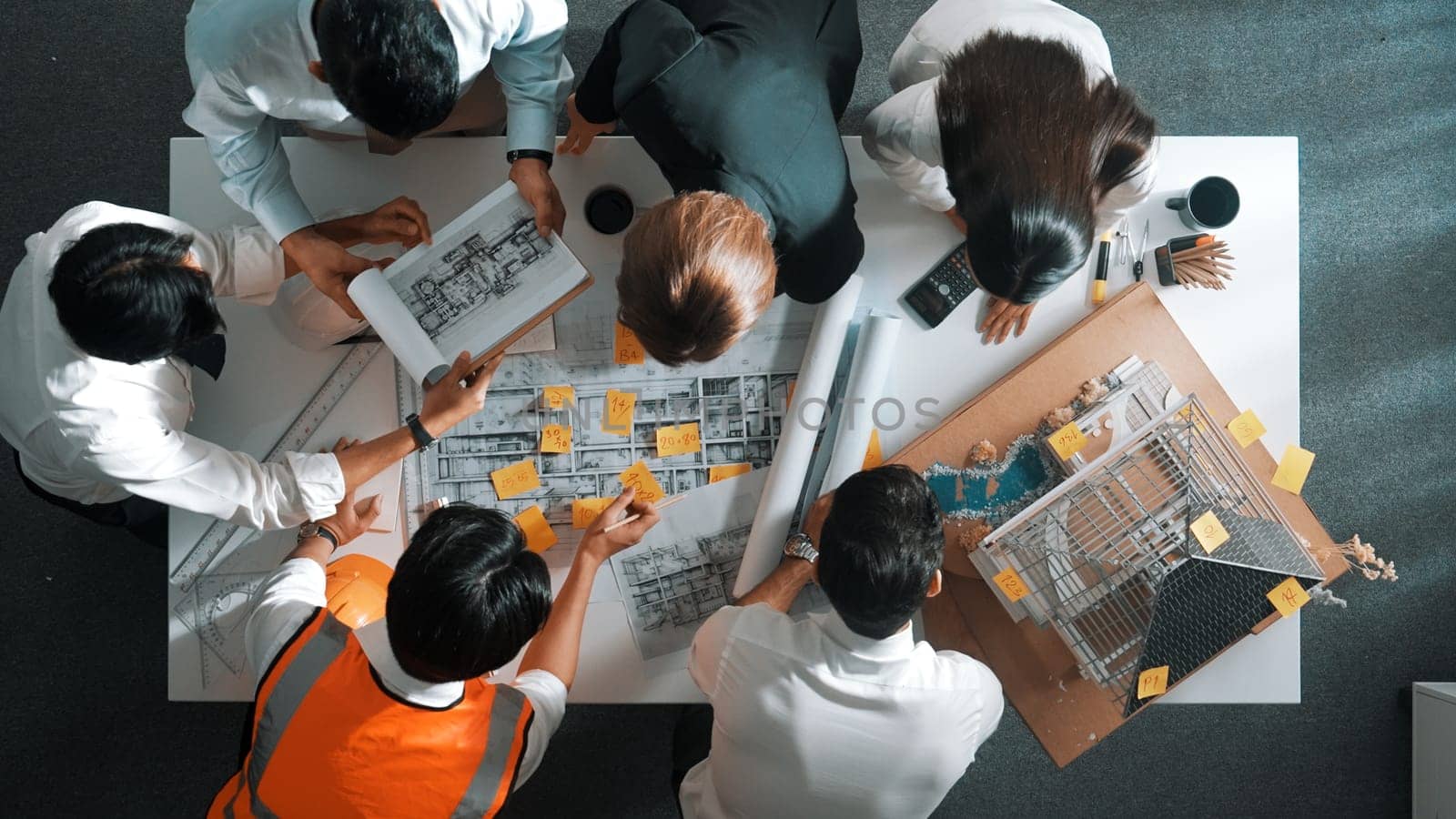 Top down view of skilled engineer team talking while looking at project plan. Aerial view of group of smart interior designer working together and planning for engineering construction. Alimentation.