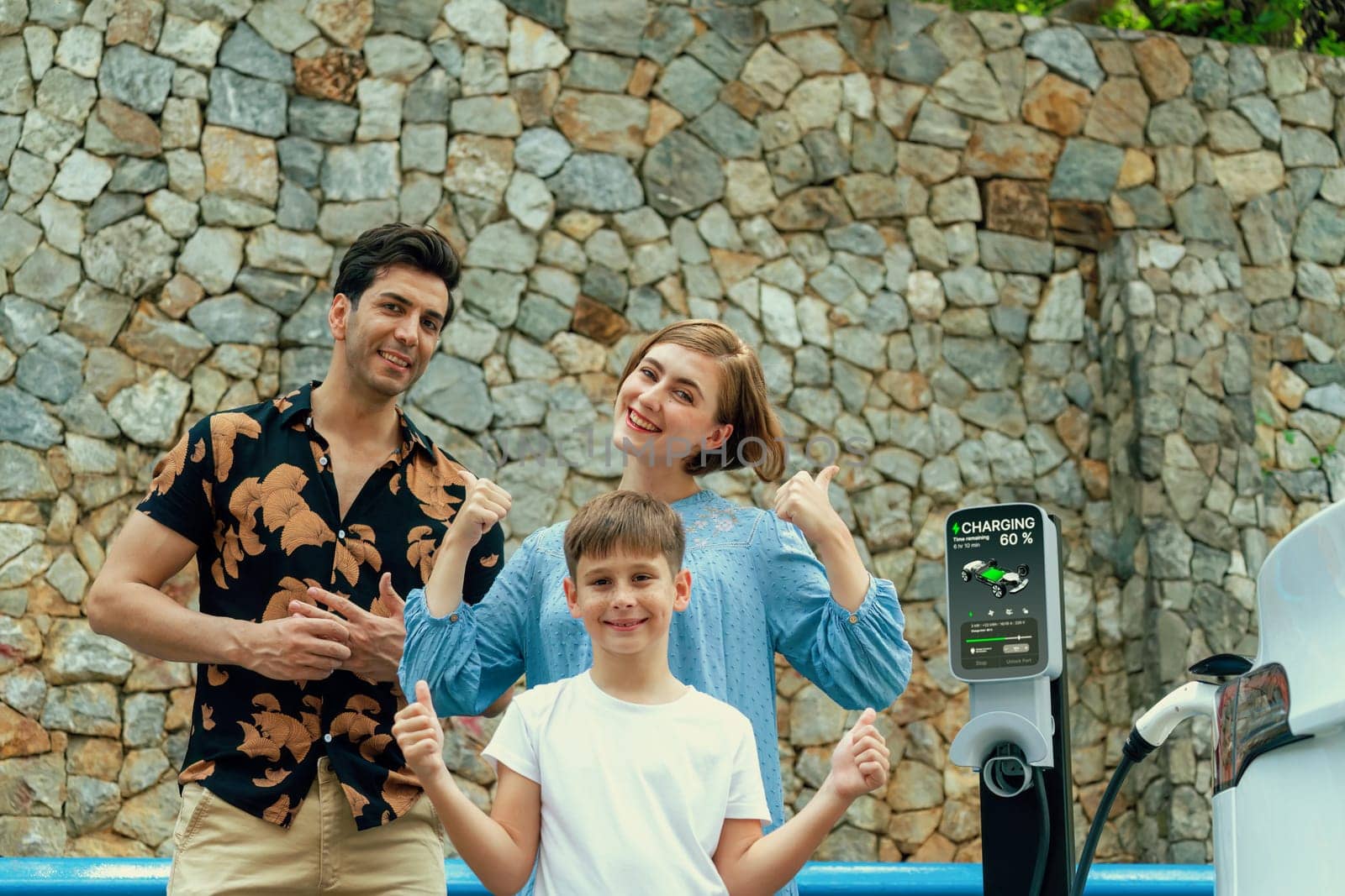 Family road trip vacation with electric vehicle, lovely family recharge EV car with green and clean energy. Stone seawall background and eco friendly car travel for sustainable environment. Perpetual