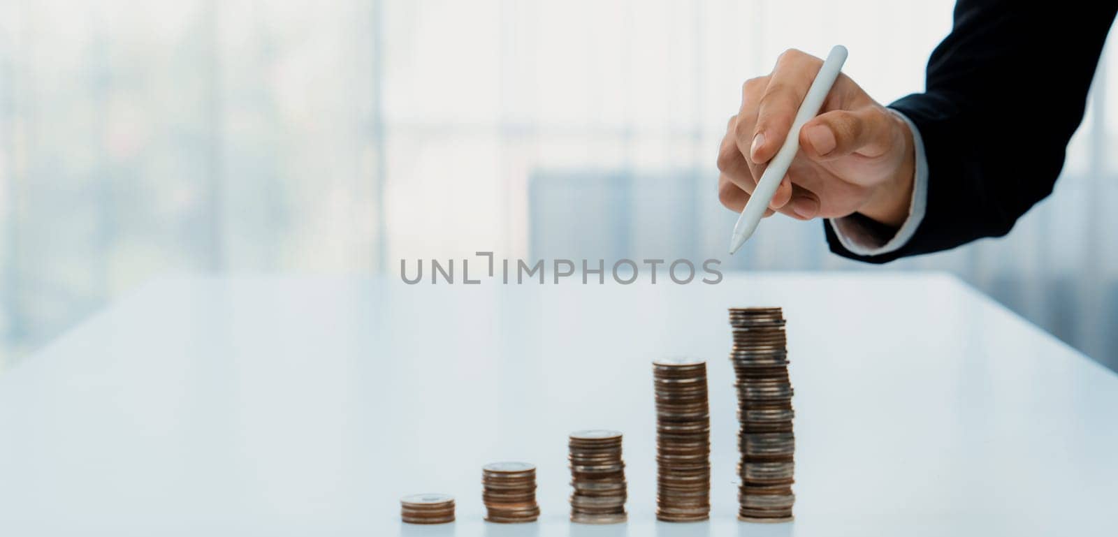 Growth coin stack symbolizing business investment and economic growth. Business people doing financial planning to achieve financial goal and contribute maximum profit gain . Shrewd