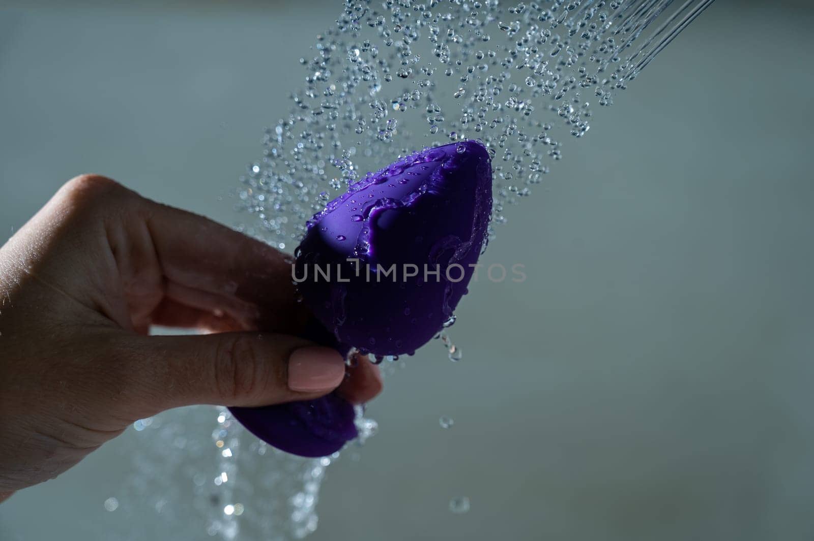 Woman washing her purple anal plug in the shower