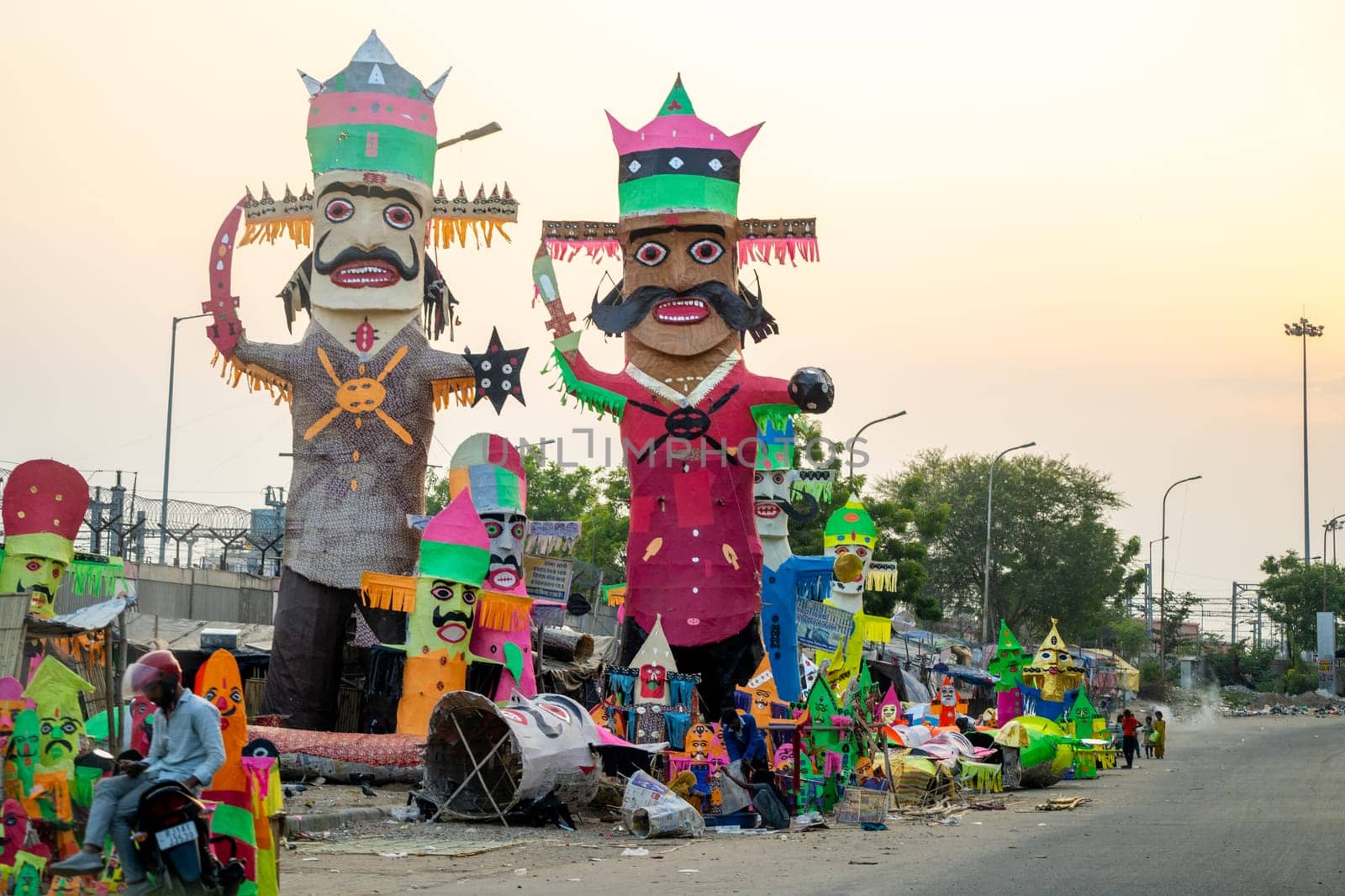 People walking in front of huge colorful effigies of Ravana made of paper on the hindu festival of Dussehra Vijayadashami by Shalinimathur